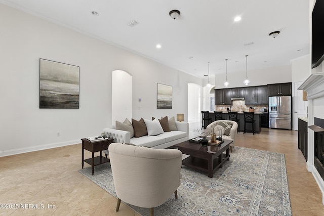 1098 Spanish Bay Ct, Orange Park, FL 32065 - living room featuring arched walkways, light tile patterned flooring, recessed lighting, ornamental molding, and baseboards