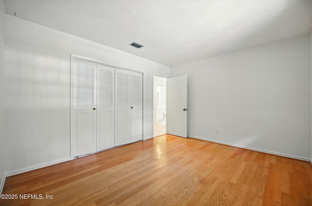 7704 Clover Ln, Keystone Heights, FL 32656 - unfurnished bedroom with wood finished floors, baseboards, and a closet