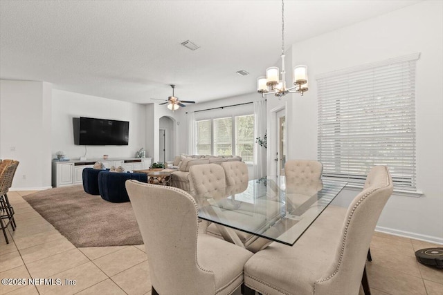 445 Huffner Hill Cir, Saint Augustine, FL 32092 - dining area with light tile patterned floors, a chandelier, baseboards, arched walkways, and a ceiling fan