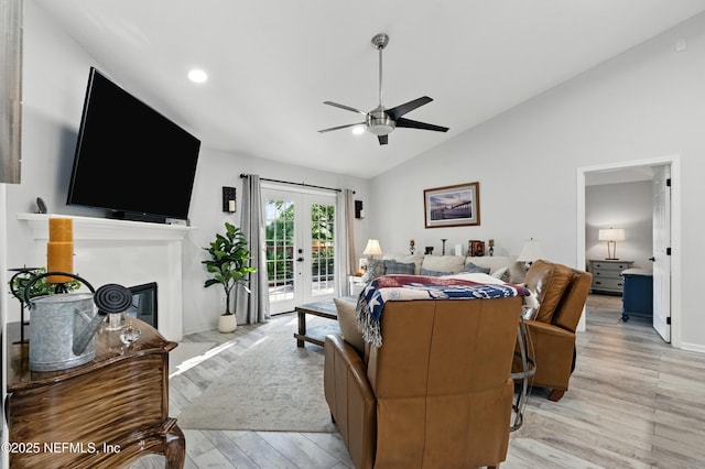 12489 Windy Willows Dr N, Jacksonville, FL 32225 - living area with lofted ceiling, ceiling fan, light wood-type flooring, a glass covered fireplace, and french doors