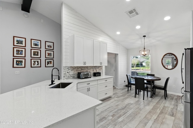 12489 Windy Willows Dr N, Jacksonville, FL 32225 - kitchen with a sink, vaulted ceiling, freestanding refrigerator, white cabinets, and recessed lighting
