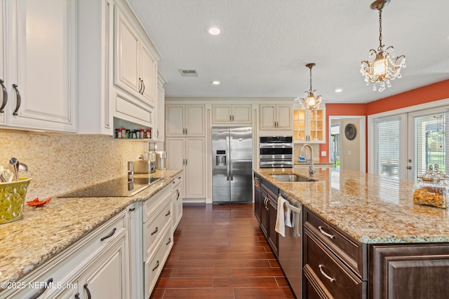595 Glasgow Ct, Orange Park, FL 32073 - kitchen with appliances with stainless steel finishes, a sink, backsplash, dark brown cabinetry, and a chandelier