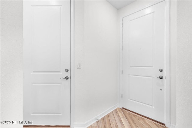 doorway to outside featuring light wood-style flooring and baseboards
