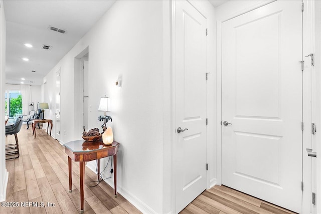 corridor featuring light wood-style flooring, recessed lighting, and baseboards