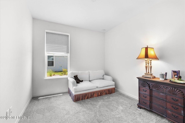 living area featuring carpet and baseboards
