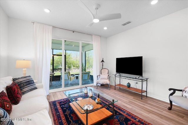living room featuring a ceiling fan, wood finished floors, baseboards, and recessed lighting