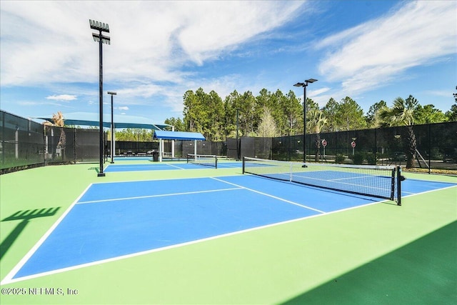 view of tennis court featuring fence and community basketball court
