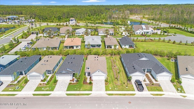 aerial view of residential area with a forest and a nearby body of water
