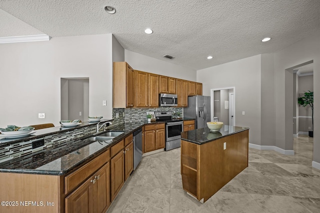 13759 Wingfield Pl, Jacksonville, FL 32224 - kitchen with stainless steel appliances, a sink, a center island, a peninsula, and dark stone countertops