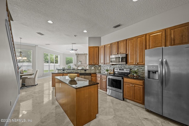 13759 Wingfield Pl, Jacksonville, FL 32224 - kitchen featuring stainless steel appliances, a peninsula, brown cabinetry, baseboards, and backsplash