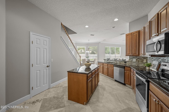 13759 Wingfield Pl, Jacksonville, FL 32224 - kitchen featuring stainless steel appliances, brown cabinetry, a kitchen island, tasteful backsplash, and baseboards