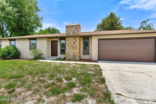 1169 Tumbleweed Dr, Orange Park, FL 32065 - view of front of home featuring stucco siding, a chimney, an attached garage, driveway, and a front lawn