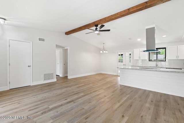 1169 Tumbleweed Dr, Orange Park, FL 32065 - unfurnished living room featuring light wood finished floors, ceiling fan, a chandelier, baseboards, and a sink