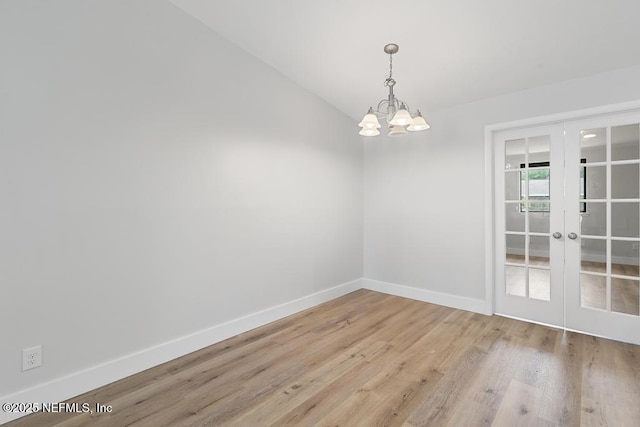 1169 Tumbleweed Dr, Orange Park, FL 32065 - spare room featuring french doors, a chandelier, wood finished floors, baseboards, and vaulted ceiling