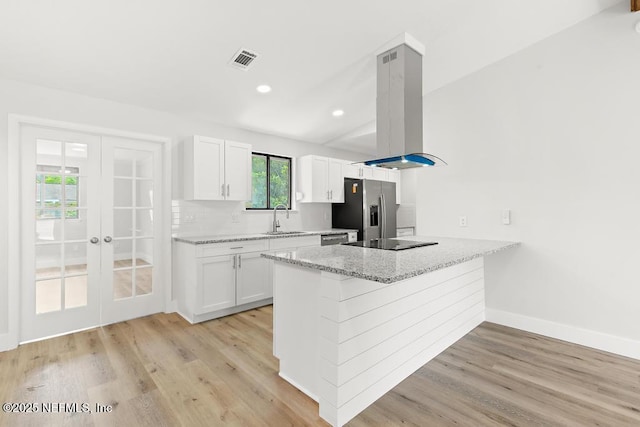 1169 Tumbleweed Dr, Orange Park, FL 32065 - kitchen with island exhaust hood, stainless steel refrigerator with ice dispenser, a sink, white cabinets, and recessed lighting