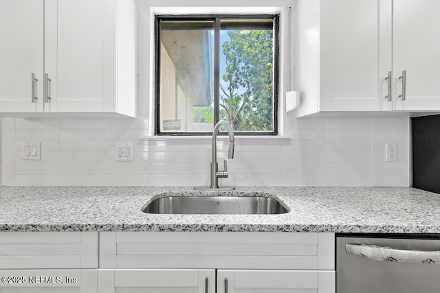1169 Tumbleweed Dr, Orange Park, FL 32065 - kitchen featuring stainless steel dishwasher, a sink, white cabinetry, and tasteful backsplash