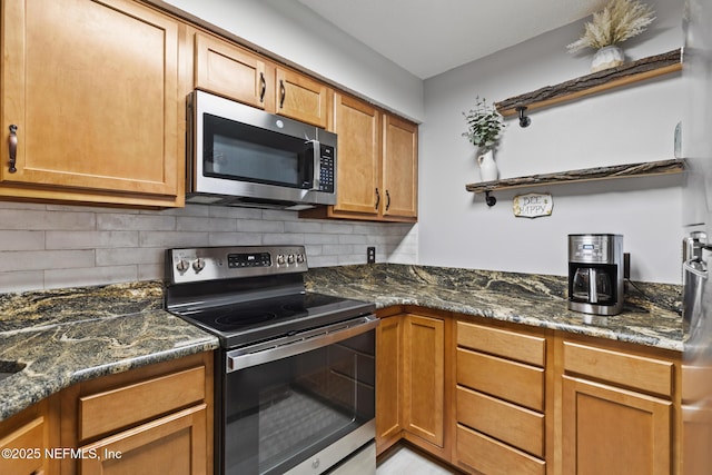 15 Ponte Vedra Ct Unit C, Ponte Vedra Beach, FL 32082 - kitchen featuring stainless steel appliances, backsplash, dark stone counters, and brown cabinetry