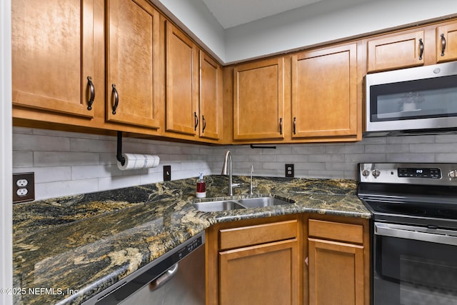 15 Ponte Vedra Ct Unit C, Ponte Vedra Beach, FL 32082 - kitchen with appliances with stainless steel finishes, a sink, backsplash, brown cabinets, and dark stone counters