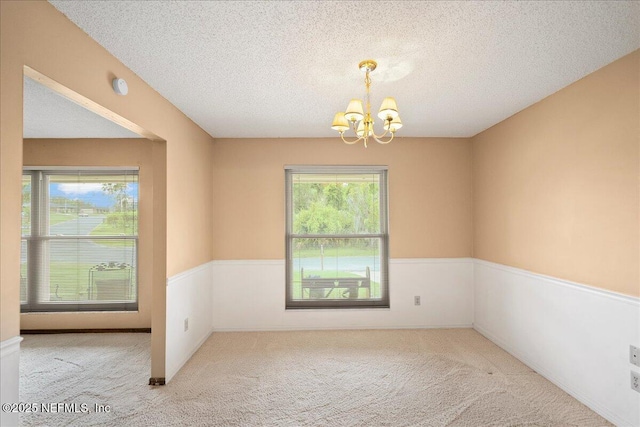 905 Ridgeway Ct, Orange Park, FL 32065 - spare room featuring a chandelier, healthy amount of natural light, carpet floors, a textured ceiling, and a wainscoted wall
