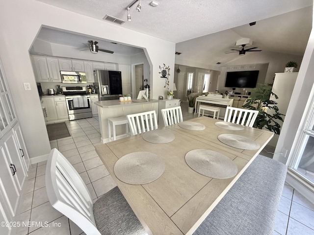 12753 Burning Tree Ln W, Jacksonville, FL 32223 - dining area featuring a ceiling fan, light tile patterned floors, plenty of natural light, lofted ceiling, and a textured ceiling
