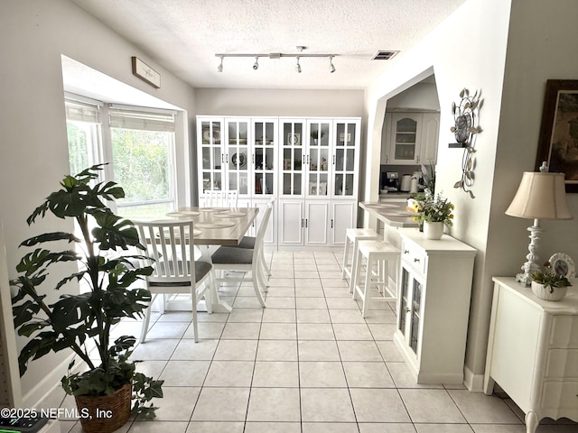 12753 Burning Tree Ln W, Jacksonville, FL 32223 - dining room with light tile patterned floors, a textured ceiling, and track lighting