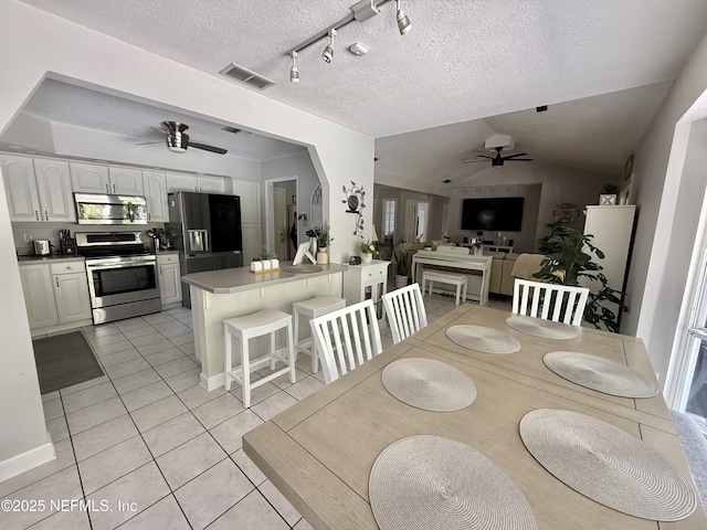 12753 Burning Tree Ln W, Jacksonville, FL 32223 - dining room featuring ceiling fan, light tile patterned floors, vaulted ceiling, and a textured ceiling