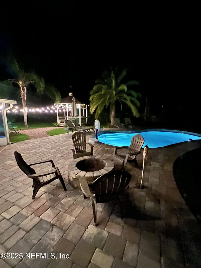 12753 Burning Tree Ln W, Jacksonville, FL 32223 - pool at night with a patio, an outdoor pool, and an outdoor fire pit