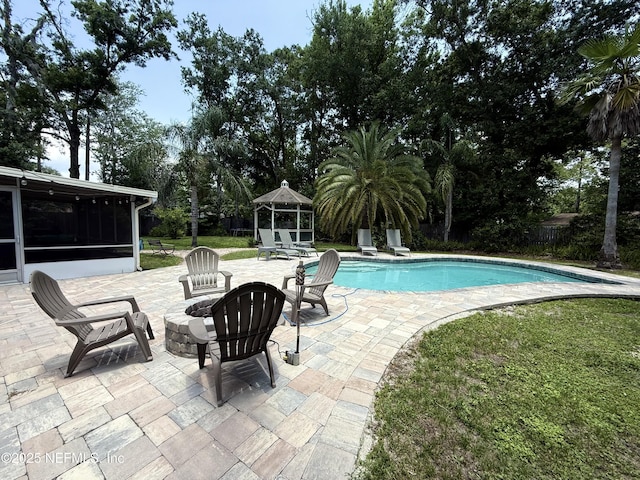 12753 Burning Tree Ln W, Jacksonville, FL 32223 - outdoor pool featuring a patio, a sunroom, a fire pit, view of scattered trees, and a yard