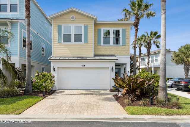2695 Morning Light Ct, Flagler Beach, FL 32136 - view of front of home with an attached garage, a standing seam roof, decorative driveway, and metal roof