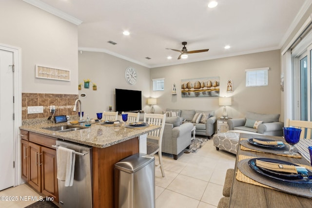 2695 Morning Light Ct, Flagler Beach, FL 32136 - kitchen featuring stainless steel dishwasher, a sink, brown cabinetry, a ceiling fan, and light tile patterned floors
