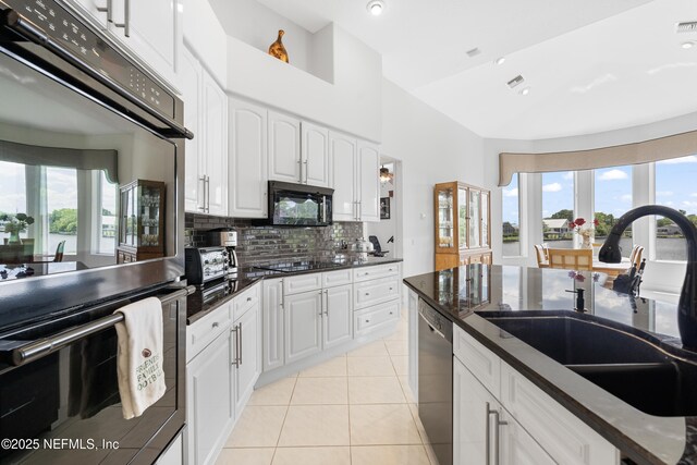 12 Collingville Ct, Palm Coast, FL 32137 - kitchen featuring black appliances, a sink, decorative backsplash, light tile patterned floors, and dark stone countertops