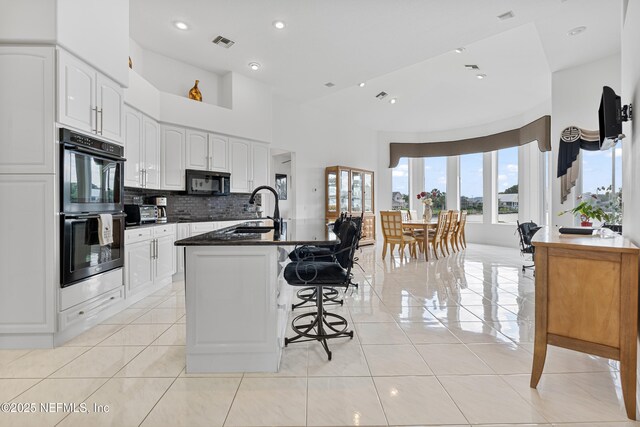 12 Collingville Ct, Palm Coast, FL 32137 - kitchen with multiple ovens, a sink, black microwave, dark countertops, and light tile patterned floors
