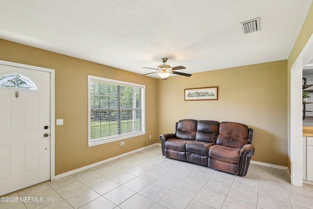 10 Sesame St, Middleburg, FL 32068 - living area featuring a ceiling fan, light tile patterned flooring, baseboards, and a textured ceiling