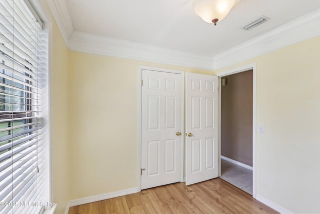 10 Sesame St, Middleburg, FL 32068 - unfurnished bedroom featuring crown molding, light wood finished floors, a closet, and baseboards