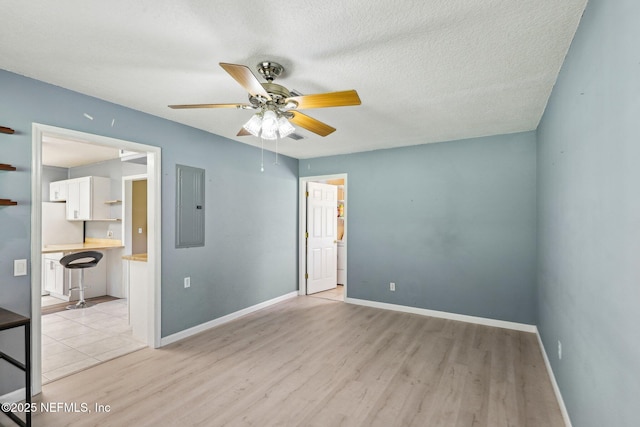 10 Sesame St, Middleburg, FL 32068 - unfurnished room with electric panel, light wood-type flooring, ceiling fan, baseboards, and a textured ceiling