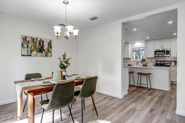 10859 Windy Gale Dr W, Jacksonville, FL 32218 - dining room featuring light wood-style flooring, a chandelier, recessed lighting, and baseboards