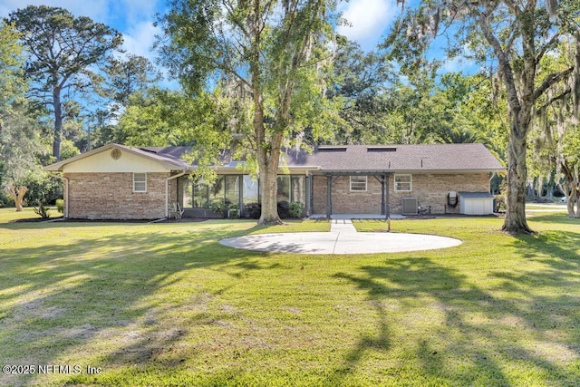 10859 Windy Gale Dr W, Jacksonville, FL 32218 - back of property with a patio, a lawn, brick siding, and a shed
