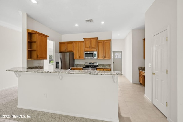 3384 Olympic Dr, Green Cove Springs, FL 32043 - kitchen with appliances with stainless steel finishes, open shelves, a peninsula, a kitchen breakfast bar, and light stone counters