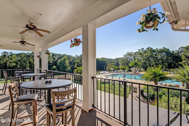 3384 Olympic Dr, Green Cove Springs, FL 32043 - balcony with view of pool, ceiling fan, view of wooded area, and outdoor dining space