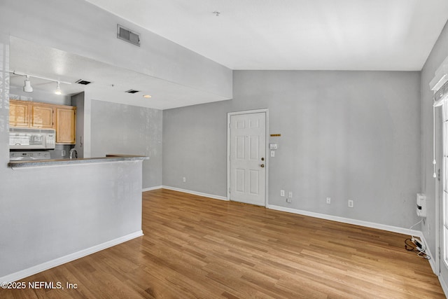 7701 Timberlin Park Blvd Unit 1535, Jacksonville, FL 32256 - unfurnished living room with rail lighting, light wood-style flooring, baseboards, lofted ceiling, and a sink