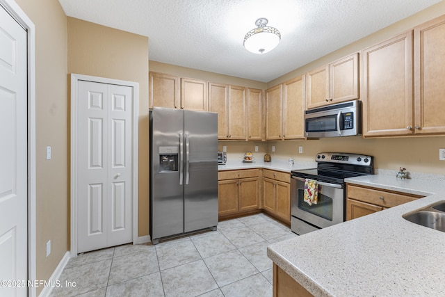 2615 Golden Lake Loop, Saint Augustine, FL 32084 - kitchen featuring stainless steel appliances, light countertops, light tile patterned flooring, and a textured ceiling