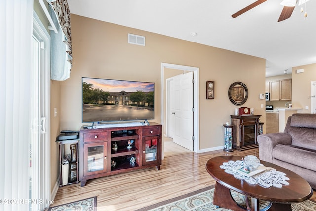 2615 Golden Lake Loop, Saint Augustine, FL 32084 - living room with a ceiling fan, light wood-type flooring, a glass covered fireplace, and baseboards