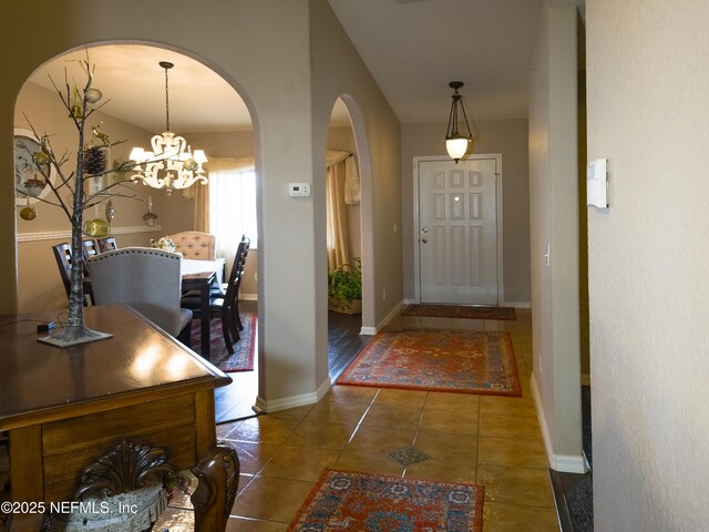 10031 SW 62nd Cir, Ocala, FL 34476 - foyer entrance featuring arched walkways, tile patterned floors, a chandelier, and baseboards