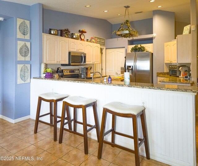 10031 SW 62nd Cir, Ocala, FL 34476 - kitchen featuring stainless steel appliances, a peninsula, stone countertops, light tile patterned flooring, and recessed lighting