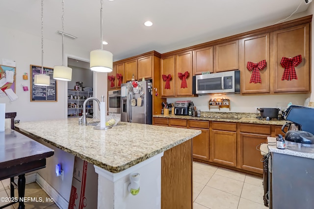 1071 Wetland Ridge Cir, Middleburg, FL 32068 - kitchen featuring stainless steel appliances, light tile patterned floors, brown cabinets, light stone countertops, and recessed lighting