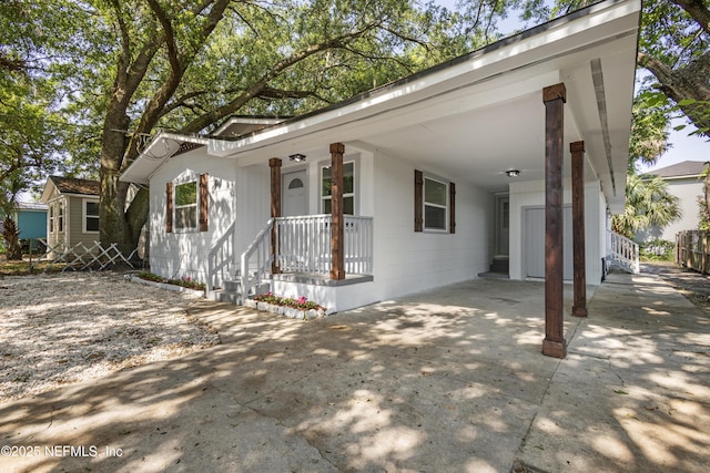 2210 Lamee Ave, Jacksonville, FL 32207 - view of front of house featuring an attached carport, driveway, and covered porch