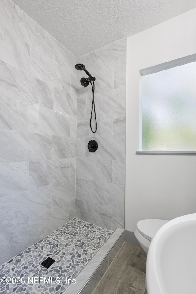 2210 Lamee Ave, Jacksonville, FL 32207 - full bath featuring a textured ceiling, tiled shower, and toilet