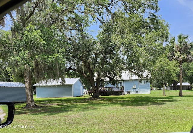 109 Laurel Ln, Crescent City, FL 32112 - view of grassy yard featuring an outbuilding and a deck