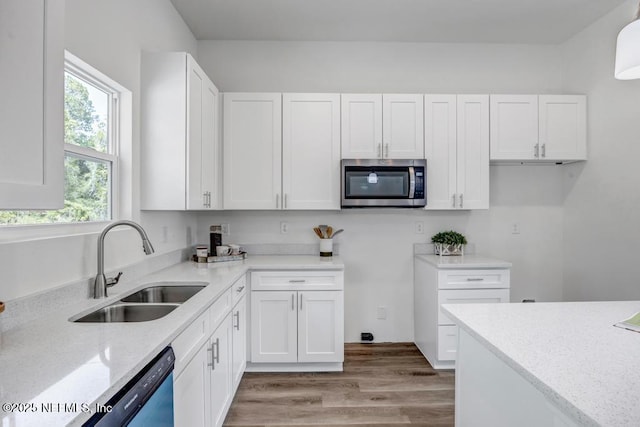4410 Vicki St, Hastings, FL 32145 - kitchen with stainless steel microwave, a sink, white cabinets, and light stone countertops