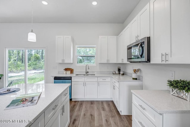 4410 Vicki St, Hastings, FL 32145 - kitchen featuring stainless steel microwave, a sink, recessed lighting, white cabinets, and light wood finished floors